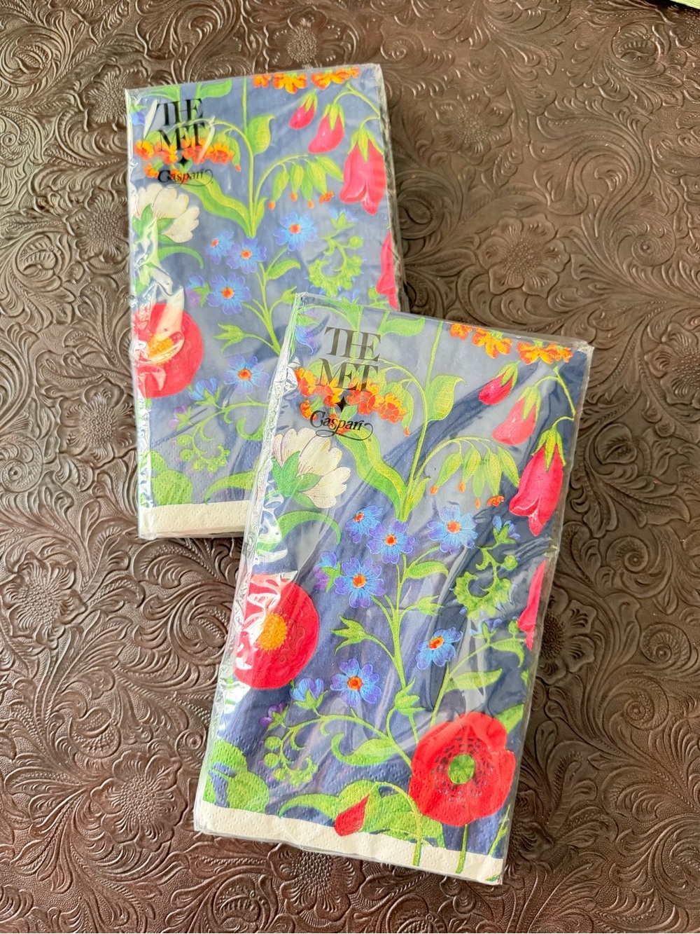 Two packages of Caspari Cloisters Garden cocktail napkins.